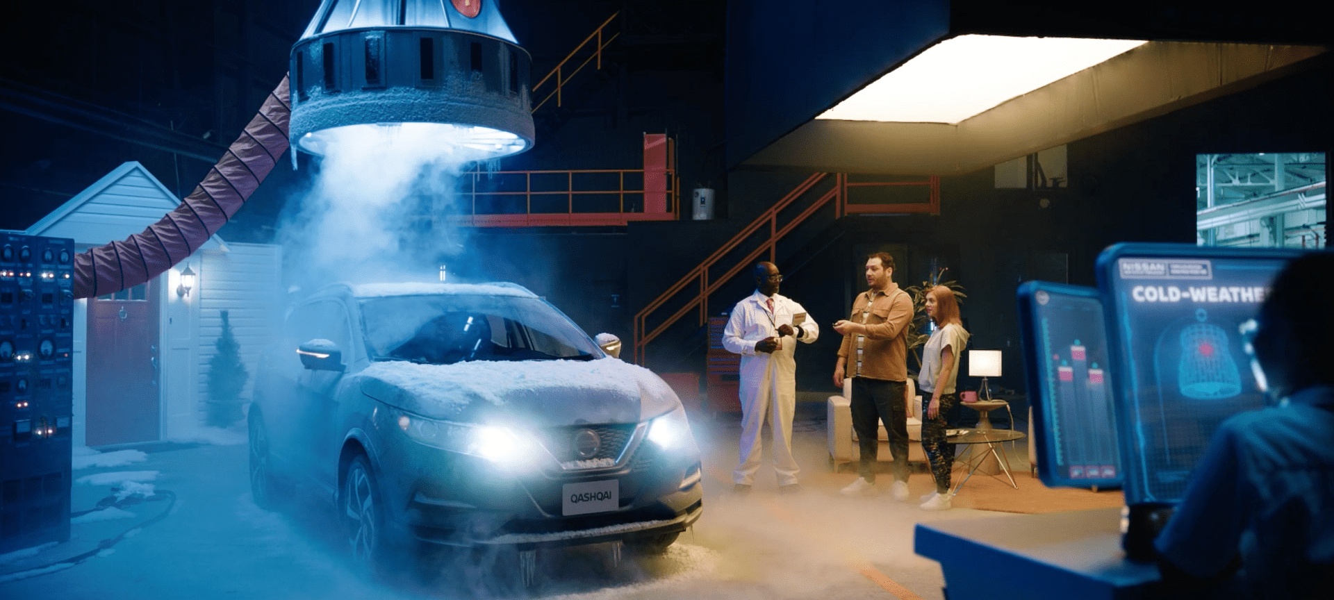 Cold-weather testing chamber where a Nissan is covered in snow. Three researchers, known as Thrillologists, observe the vehicle's performance while a high-tech monitor displays cold-weather data