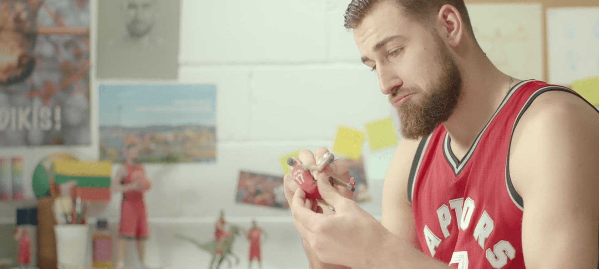 Jonas Valančiūnas intently painting one of the small figurines from his Itty Bitty Ballers collection, showcasing the humorous DIY element of the campaign