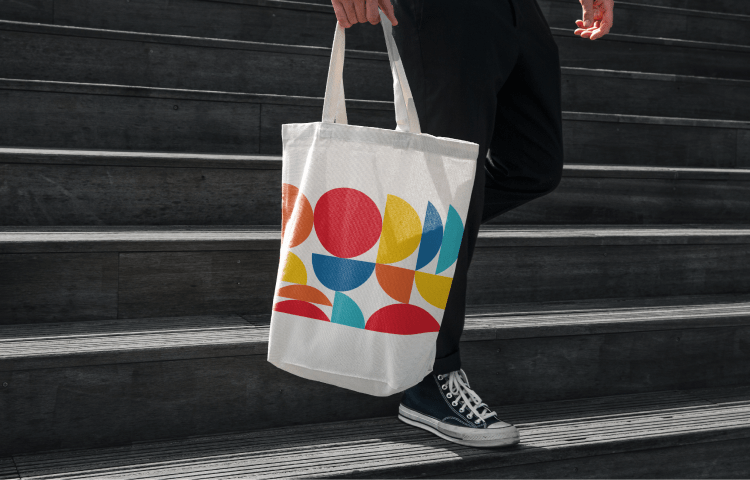 White tote bag featuring CBC’s colourful geometric logo design