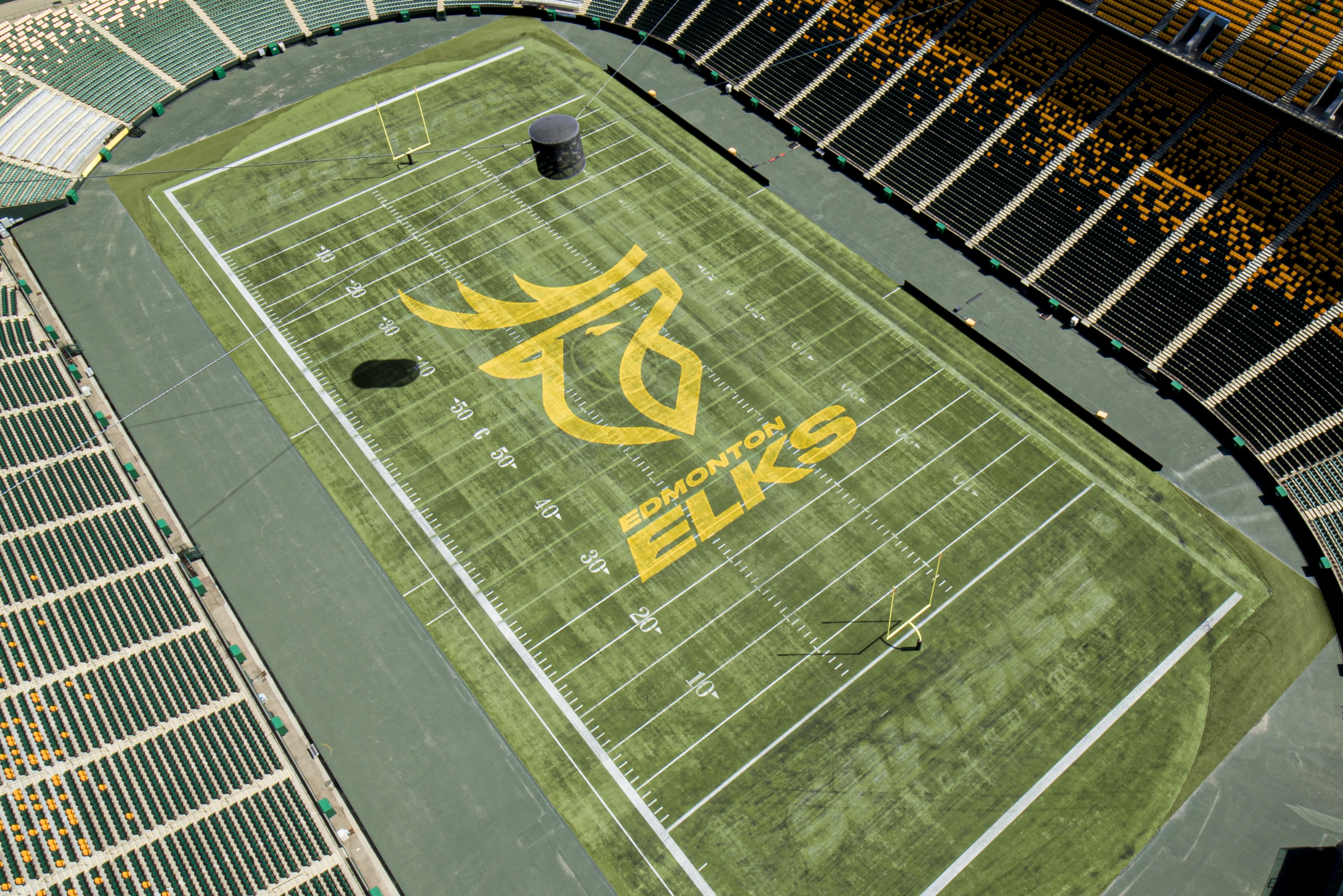 Aerial view of the Edmonton Elks football field, featuring the team's large yellow elk head logo and 'Edmonton Elks' text at midfield